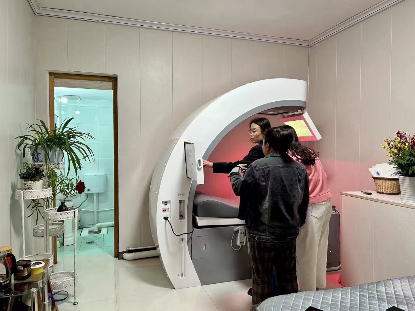 Therapist operating touchscreen controls on modern colonic machine